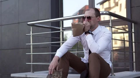 Upset man tries to calm down by breathing into a paper bag. Stock Footage 243828448