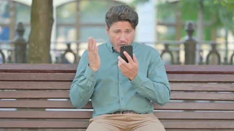 Upset Middle Aged Man Reacting to Loss on Smartphone Stock Footage 157513465
