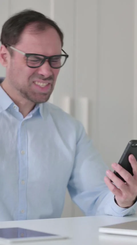 Upset Middle Aged Man Reacting to Loss on Smartphone, Vertical Video 스톡 동영상 339584963