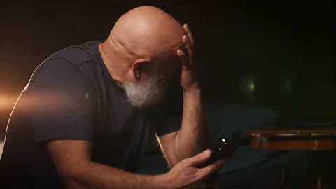 Upset middle-aged man reads message on phone and cries, cyberbullying Stock Footage 346714262