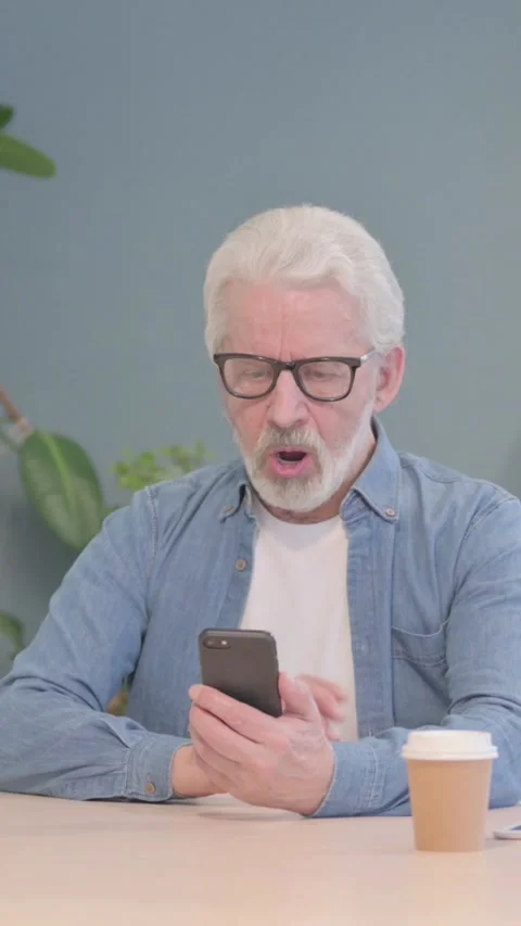 Upset Old Man Reacting to Loss on Smartphone, vertical video Stock Footage 329106622