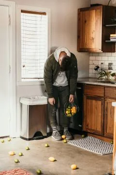 Upset Person Spills Basket of Lemons and Lime Fruit on the Kitchen Floor Stock Photos