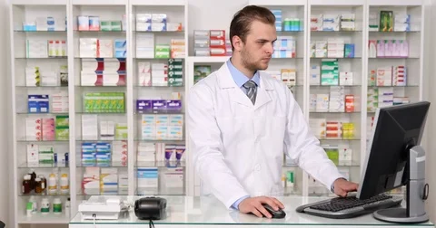 Upset Pharmacist Man Talking Mobile Phone Angry Response Using Computer Pharmacy Stock Footage 77003768
