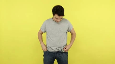 Upset poor young man showing empty pockets, having no money, debt, financial Video stock 148357128