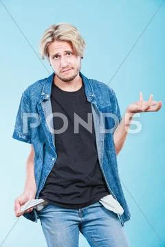 Upset sad man showing empty pockets Stock Photos