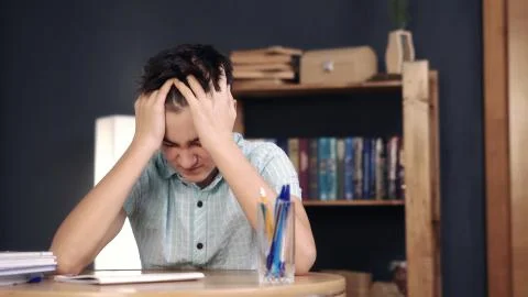 Upset schoolboy doing homework Stock Photos
