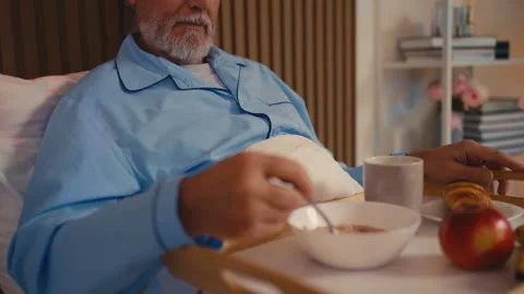 Upset senior male refusing to eat breakfast while lying in bed at a nursing home Stock Footage 279177571