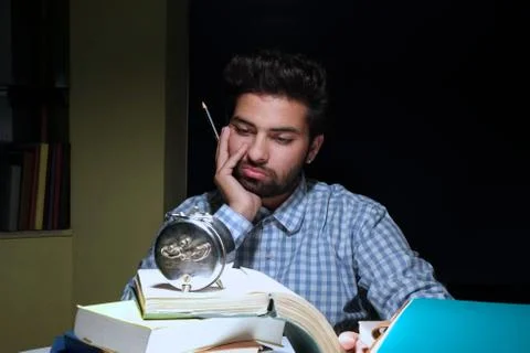 Upset student looking at time during exam preparation. Stock Photos