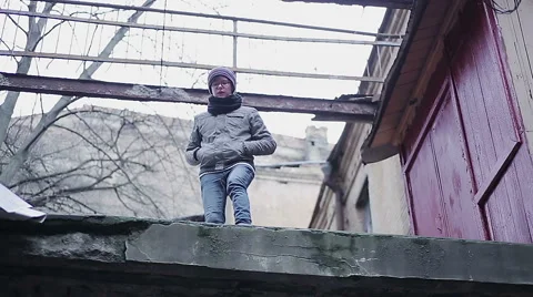 Upset teenager about to commit suicide by jumping from roof, changing his mind Stock Footage 62589213