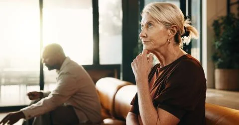 Upset, thinking and couple on sofa in home with conflict, disagreement or d.. Stock Photos