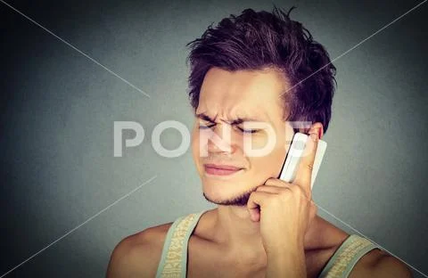 Upset unhappy guy talking on cellphone Stock Photos