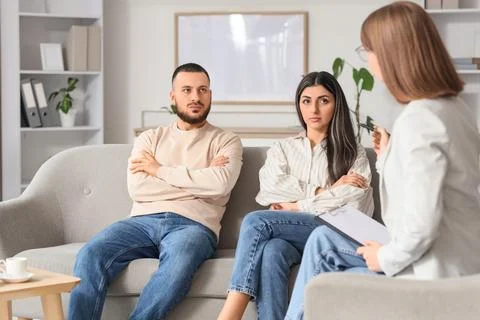 Upset young couple discussing problems with family mediator in office Photos