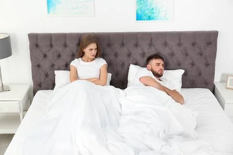 Upset young couple with relationship problems in bedroom Stock Photos