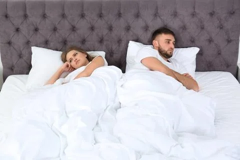 Upset young couple with relationship problems in bedroom Stock Photos