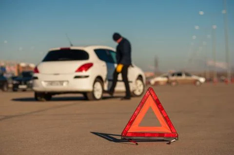 Upset young man checking wheel after car breakdown Stock Photos