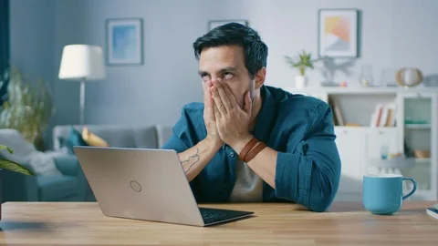 Upset Young Man Covers His Face with Palms in Frustration While Getting Bad News Stock Footage