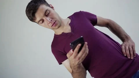 Upset young man looking at smartphone screen, dissatisfied with bad news message Stock Footage 208373452