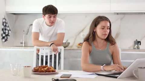Upset young woman sitting at computer with her back to her husband disputing Stock Footage 344844071
