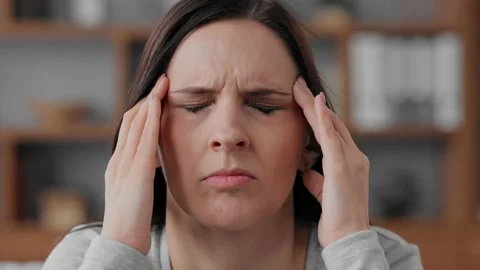 Upset young woman suffering from headache. Exhausted woman with closed eyes Stock Footage 195017953