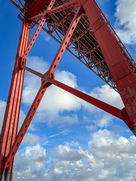 Upshot view of red bridge structure at blue sky with clouds on sunny day Foto stock