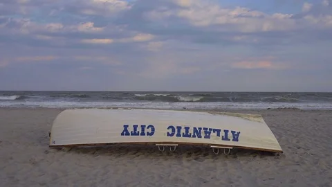 Upside down Atlantic City, New Jersey rowboat on beach at sunset Stock Footage 72724391