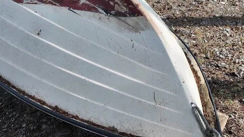 Upside down boat resting on sandy shore near calm sea Stock Footage 331892272