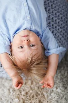 Upside down boy on pouf Stock Photos