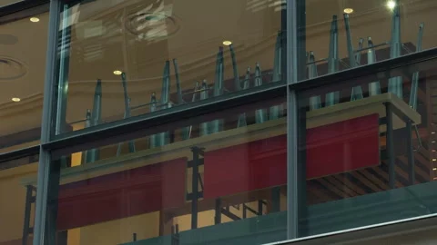 Upside down chairs stacked on tables inside empty cafe behind glass windows Stock Footage 337735740