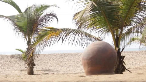 Upside down clay pot on a sandy beach with palm trees Stock Footage 111280308