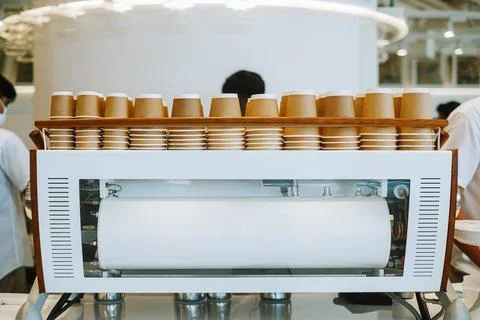 Upside-down disposable cardboard cups on espresso machine Stock Photos