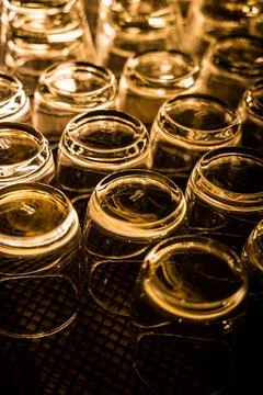 Upside down glass cups drying rack golden light reflection Stock Photos