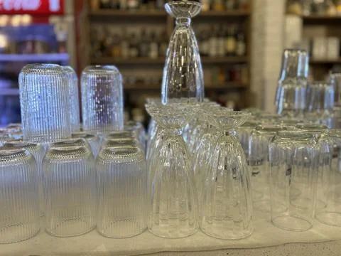 Upside-down glassware set on shelf in bar or restaurant with various drink .. 스톡 사진
