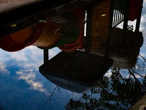 Upside Down Reflection of Colorful Playground Slide in Rain Puddle, Abstrac.. Stock Photos