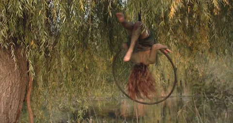 Upside down spin in a hoop in the forest, dryad cosplay, young pretty woman, 4k Stock Footage 167361182