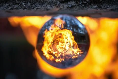 Upside down view through the lensball on blurred campfire in forest Stock Photos