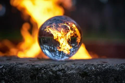 Upside down view through the lensball on blurred campfire in forest Stock Photos