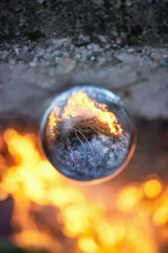 Upside down view through the lensball on blurred campfire in forest Foto stock