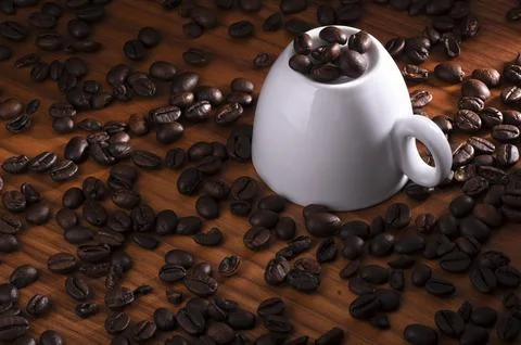 Upside down white cup with coffee bean Stock Photos