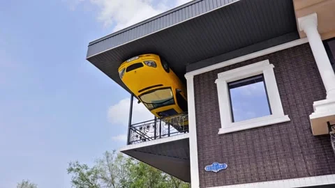 Upside Down Yellow Car Art Installation on Modern House Balcony 库存影片 332965163