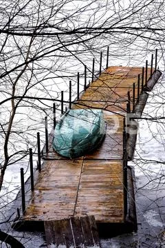 Upturned boat green lies on the dock during the formation of ice. The view fr Stock Photos