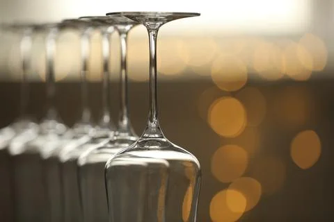 Upturned empty clean glasses on blurred background, closeup. Space for text Stock Photos