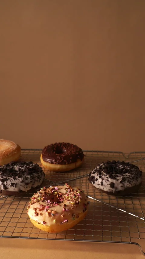 Upward Camera Move Over Assorted Donuts on Cooling Rack Stock Footage 331233392