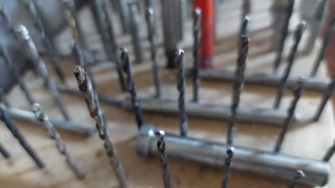Upward camera tilt showing collection of various metal drill bits in a wooden or Stock Footage 336482694