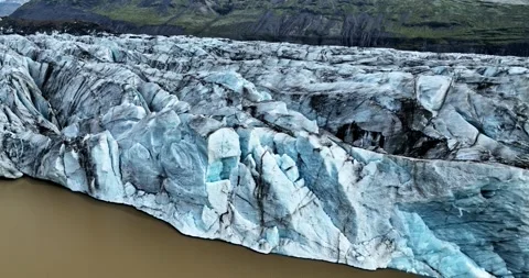 Upward drone move creates parallax over an Iceland glacier terminus above a tan Stock-Footage 325163010