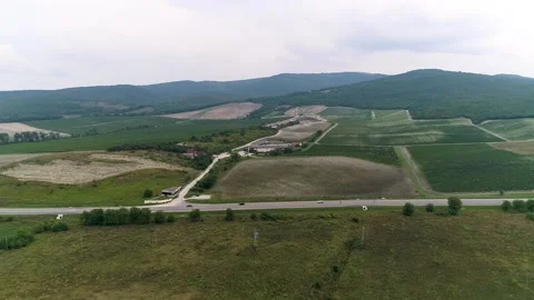 Upward flight of a drone over a vineyard and a highway in a valley Stock Footage 152045748