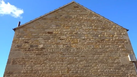 Upward pan of a stone gable wall on the outside of a renovated UK barn. Stock Footage 105115624