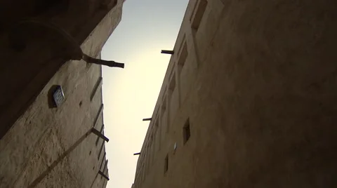 Upward pan through a narrow passage through old buildings in the Bastakiya Stock-Footage 46868612