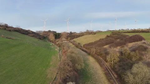 Upward tilt from meadow toward distant wind turbines Stock-Footage 331210677