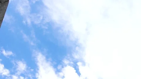 Upward tilt shows sharp white clouds on intense blue background Stock Footage 312758280