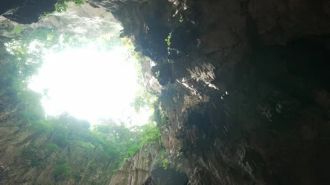 Upward View of Cave Opening with Falling Water Drops and Natural Light Stockbeeldmateriaal 334721290